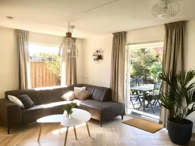 a living room with a couch and a table at Bendalong Noordwijk in Noordwijk