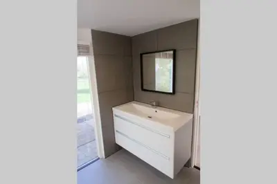 a bathroom with a white sink and a mirror at Bungalow between Amsterdam and Haarlem with sauna in Vijfhuizen