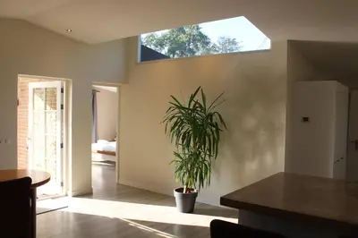 a potted plant in a room with a window at Bungalow between Amsterdam and Haarlem with sauna in Vijfhuizen