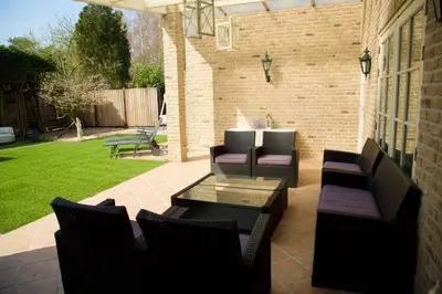 a patio with couches and a table and chairs at Bungalow between Amsterdam and Haarlem with sauna in Vijfhuizen