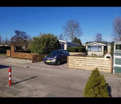 a car parked in a driveway in front of a house at Cozy chalet in Opmeer near Amsterdam and Beach in Opmeer