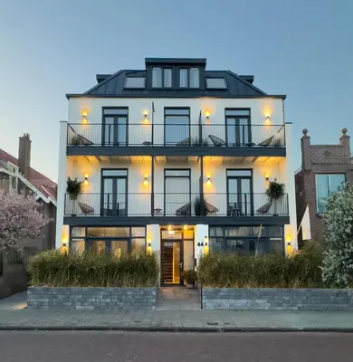 a white house with a black roof at Boutique Hotel At Sea in Zandvoort