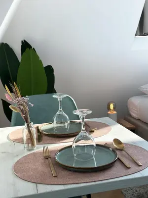 a table with two plates and glasses on it at Boutique Hotel At Sea in Zandvoort