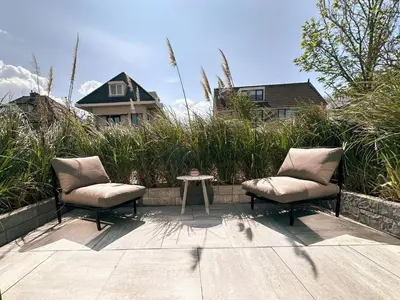 two chairs and a table on a patio at Boutique Hotel At Sea in Zandvoort