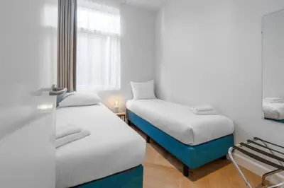 a room with two beds and a window at Boutique Hotel At Sea in Zandvoort