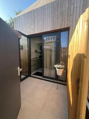 an open door to a kitchen with a pot of flowers at Beachhouse SeaBreeze - vernieuwd! in Noordwijk