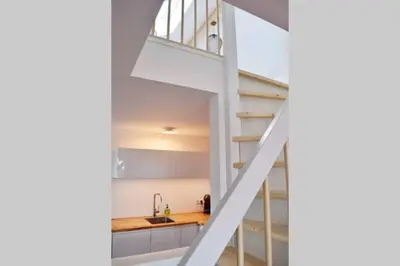 a staircase leading up to a kitchen in a house at Mooi vakantiehuis prachtig gelegen aan het water in Rijpwetering