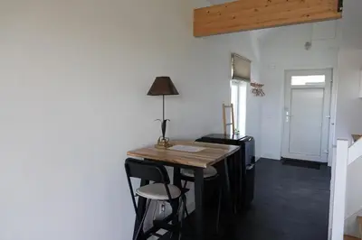 a small table in a room with chairs and a lamp at Mooi vakantiehuis prachtig gelegen aan het water in Rijpwetering