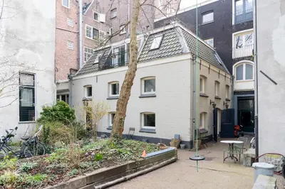 a white house with a tree in front of a building at Kloveniers Studio in Amsterdam