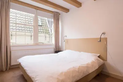 a bedroom with a white bed and a window at Kloveniers Studio in Amsterdam