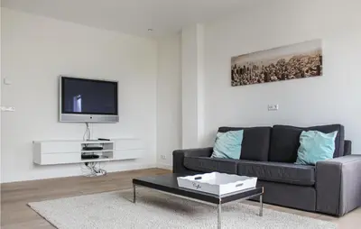 a living room with a couch and a tv at Thalatta in Noordwijk