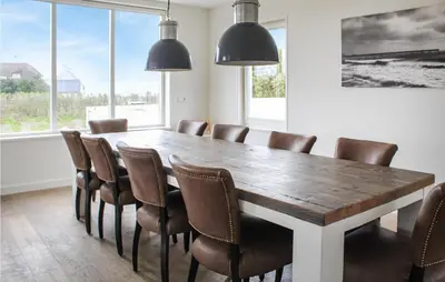 a dining room with a wooden table and chairs at Thalatta in Noordwijk