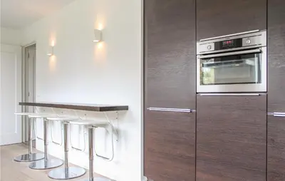 a kitchen with wooden cabinets and a stove at Thalatta in Noordwijk