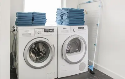 two washing machines in a laundry room with blue towels at Thalatta in Noordwijk