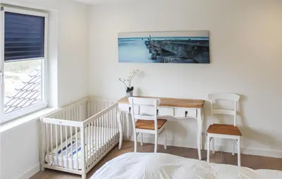 a room with a table and chairs and a crib at Thalatta in Noordwijk