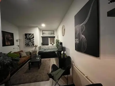 a living room with a bed and a couch at Studio E in Purmerend