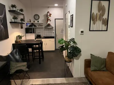 a living room and kitchen with a table and chairs at Studio E in Purmerend