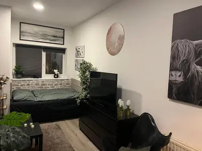 a living room with a bed and a window at Studio E in Purmerend