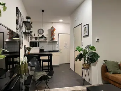 a kitchen and living room with a table and chairs at Studio E in Purmerend