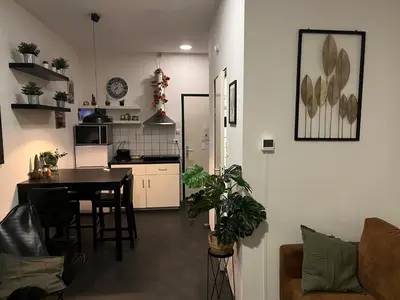 a living room with a table and a kitchen at Studio E in Purmerend
