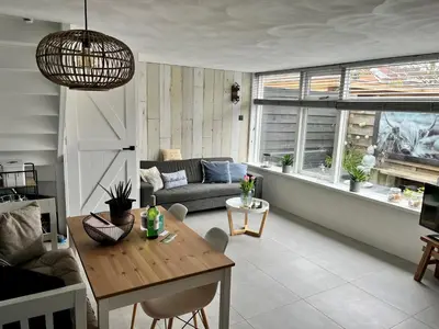 a living room with a table and a couch at HuisjehurenEgmond in Egmond aan Zee