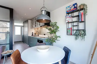 a kitchen and dining room with a white table and chairs at Shell 61 in Zandvoort