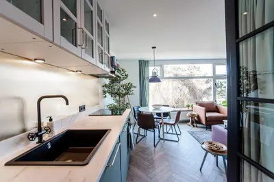 a kitchen with a sink and a living room at Shell 61 in Zandvoort