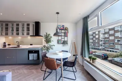 a kitchen and living room with a table and a window at Shell 61 in Zandvoort