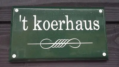 a green sign that says t korekus with anagus at 't Koerhaus in Egmond aan Zee