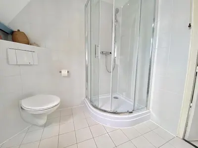 a white bathroom with a shower and a toilet at The New Fisherman’s House in Zandvoort