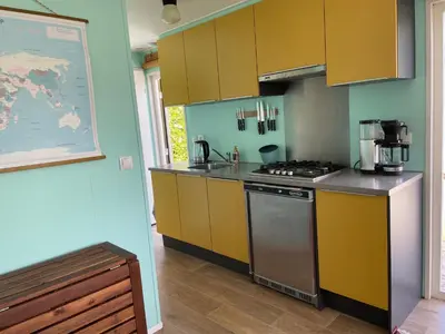 a kitchen with yellow cabinets and a stove at Summer house on the Dutch coast in IJmuiden