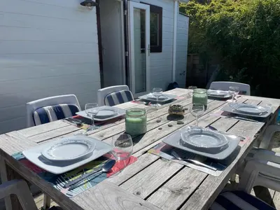 a wooden table with plates and wine glasses on it at Summer house on the Dutch coast in IJmuiden