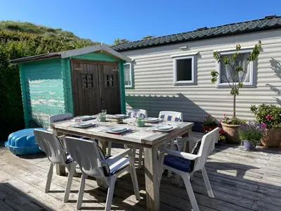 a wooden table and chairs on a patio at Summer house on the Dutch coast in IJmuiden