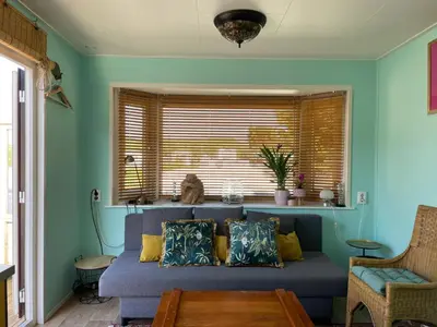 a living room with a blue couch and a window at Summer house on the Dutch coast in IJmuiden