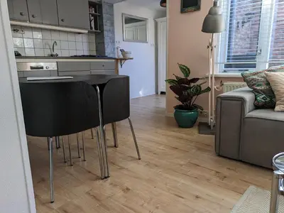 a kitchen with a black table in a living room at Knus huisje met prachtige nieuwe badkamer - Distelhoek in Egmond aan Zee