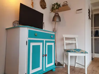 a blue cabinet with a television on top of it at Knus huisje met prachtige nieuwe badkamer - Distelhoek in Egmond aan Zee