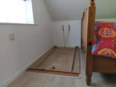 a room with a bed and a wooden floor at Knus huisje met prachtige nieuwe badkamer - Distelhoek in Egmond aan Zee