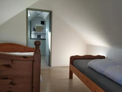 a bedroom with two beds and a mirror at Knus huisje met prachtige nieuwe badkamer - Distelhoek in Egmond aan Zee