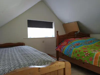 a bedroom with two beds and a window at Knus huisje met prachtige nieuwe badkamer - Distelhoek in Egmond aan Zee