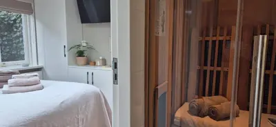 a bedroom with a bed and a window with towels at Tiny Villa de Haas met Infraroodsauna in Egmond aan Zee