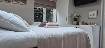 a bedroom with a white bed with towels on it at Tiny Villa de Haas met Infraroodsauna in Egmond aan Zee