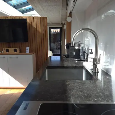 a kitchen with a black counter top and a sink at Tiny Villa de Haas met Infraroodsauna in Egmond aan Zee