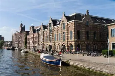 a boat in the water in front of a building at Boerencamping Swarthoeve in Wormer