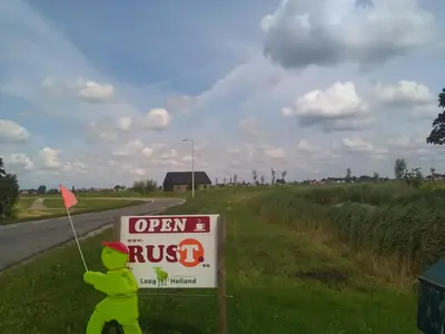 a sign on the side of a road with a bear next to it at Boerencamping Swarthoeve in Wormer