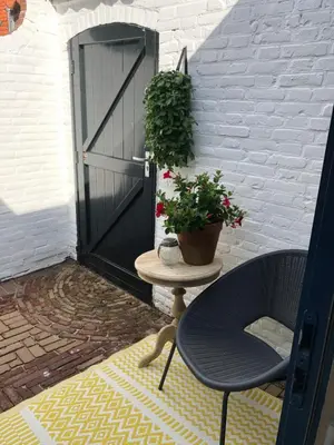 a patio with a door and a table with a plant at Zandvoortferienwohnungen in Zandvoort