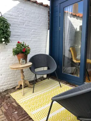 a patio with two chairs and a table with a plant at Zandvoortferienwohnungen in Zandvoort
