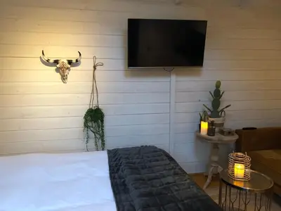 a bedroom with a bed and a tv on a wall at Zandvoortferienwohnungen in Zandvoort