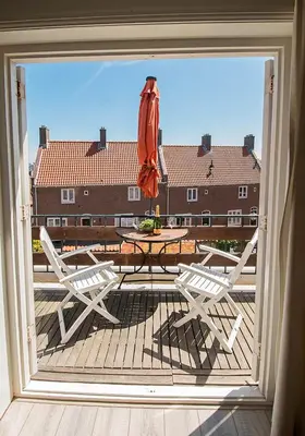 a patio with a table and chairs and an umbrella at Zandvoortferienwohnungen in Zandvoort
