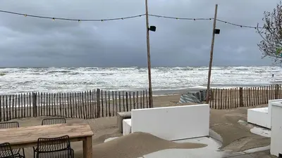a table and chairs on a beach with the ocean at Zandvoortferienwohnungen in Zandvoort