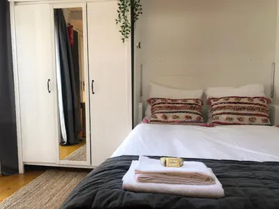 a white bed with a towel on it and a mirror at Zandvoortferienwohnungen in Zandvoort